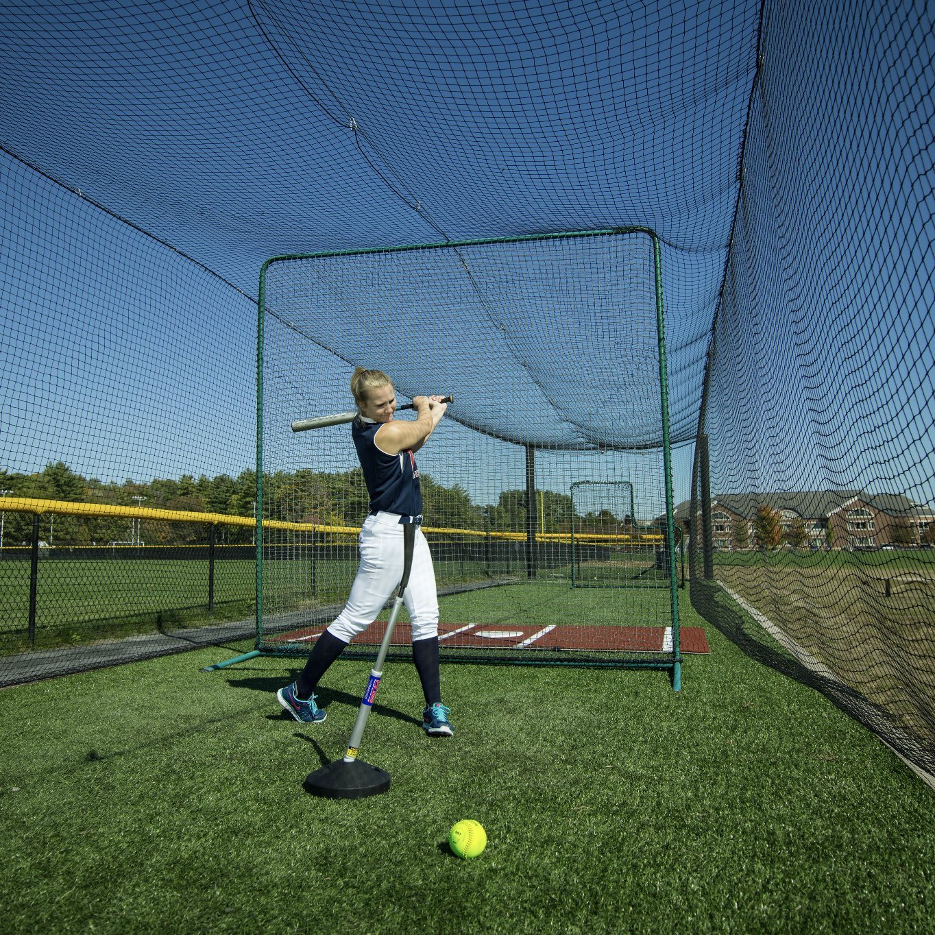 woman hitting promounds pvtee batting tee in batting cage